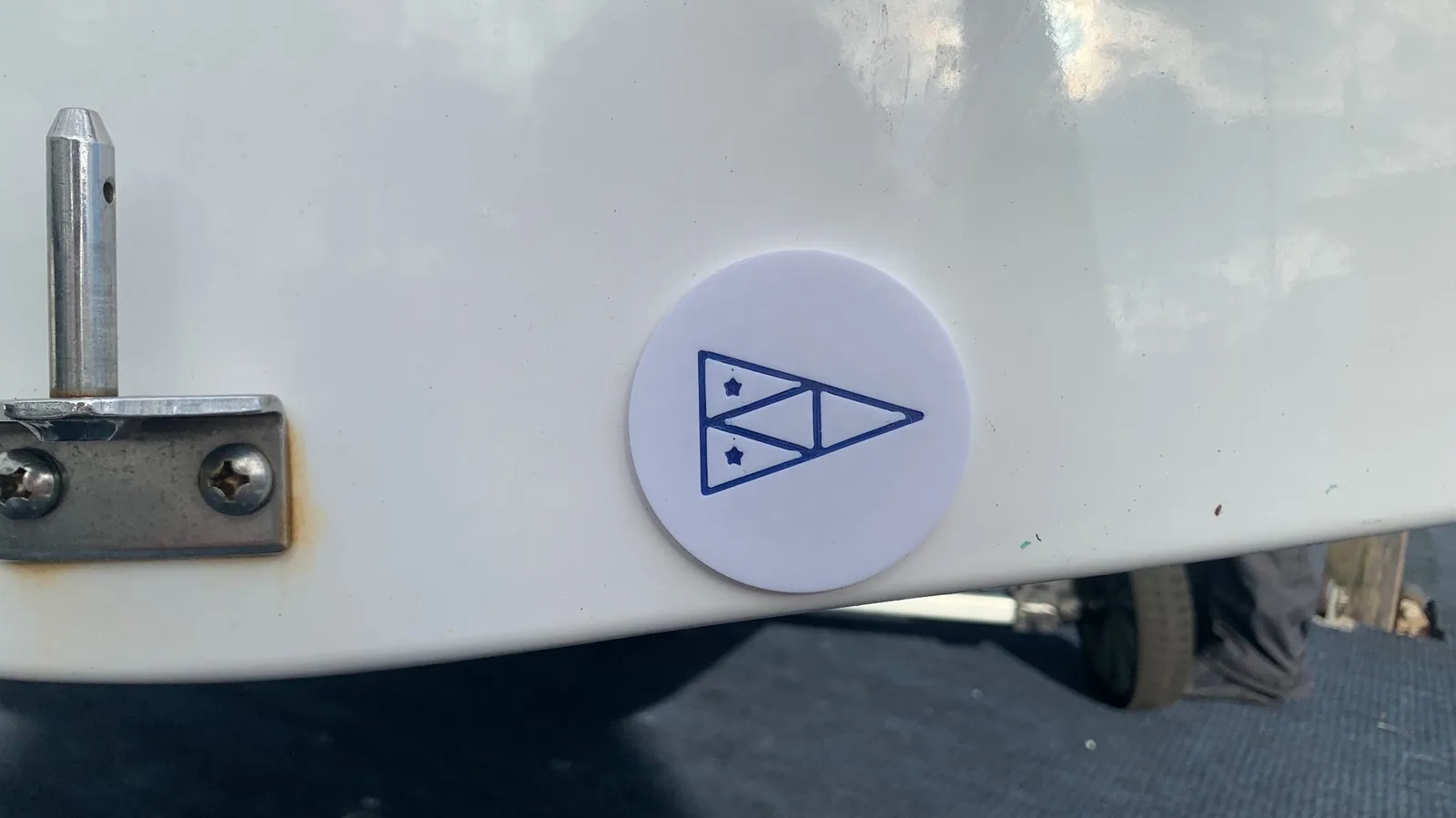 A white ProPlug fitted flush in a hull, engraved with the St. Francis Yacht Club burgee.
