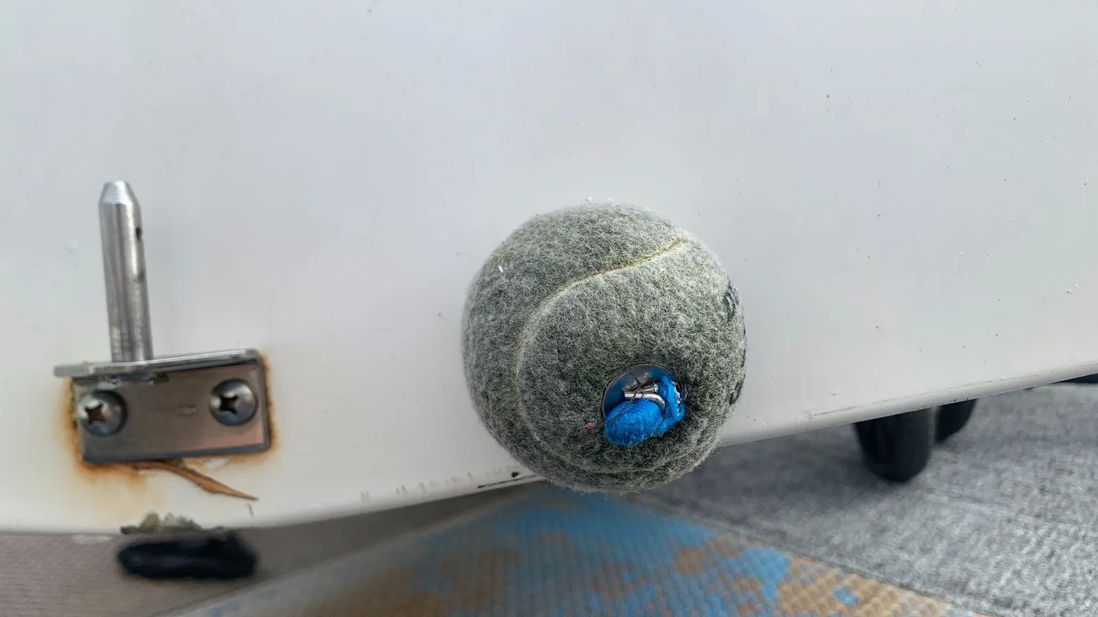 A worn tennis ball wedged into the drain hole in the transom of an FJ.